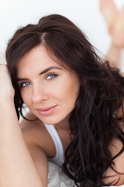 Peaceful brunette woman lying on her bed