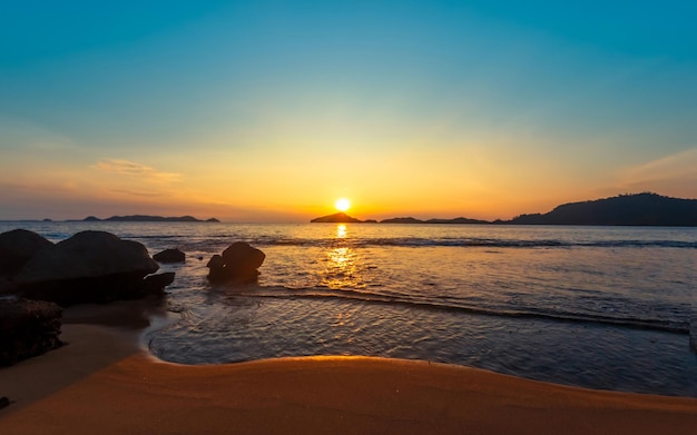 岩のある静かな穏やかなビーチの夕日