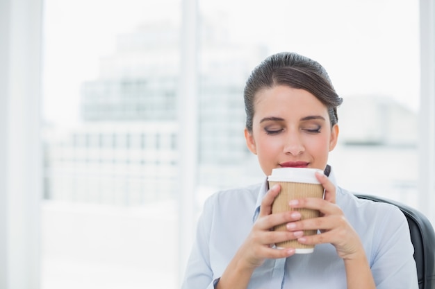 コーヒーの香りを楽しんで平和な高級茶髪の実業家