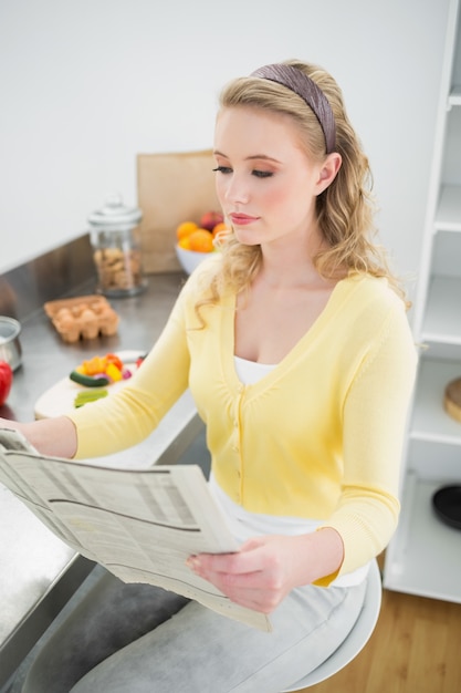 Photo peaceful cute blonde reading newspaper