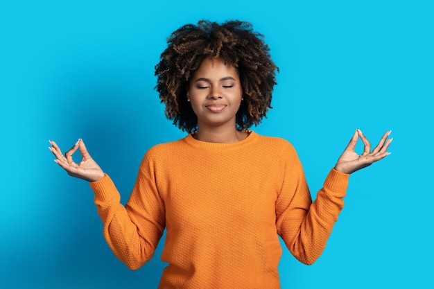 Photo peaceful relaxed black woman meditating on blue