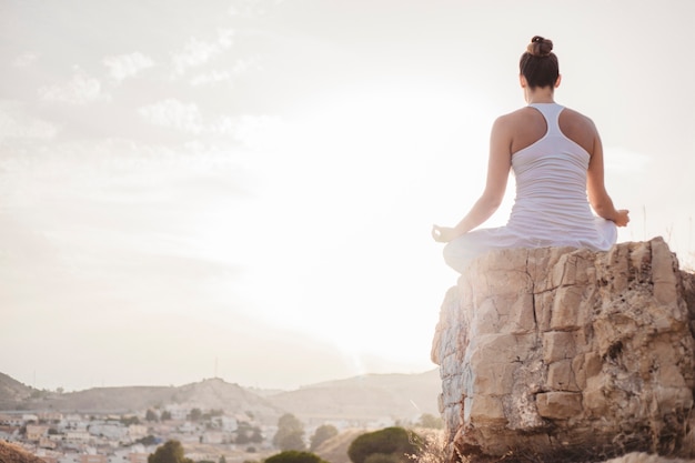 Donna pacifica meditando al tramonto