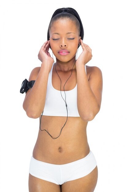 Peaceful woman in sportswear listening to music