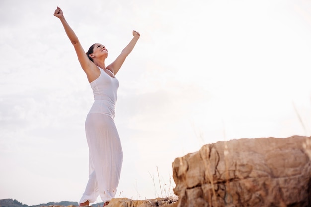 Peaceful woman stretching arms towards sky