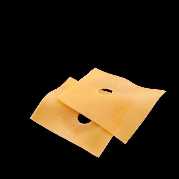 Peaces of yellow cheese flying on a black