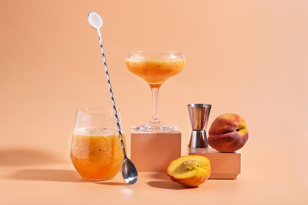 A peach cocktail with a spoon next to it