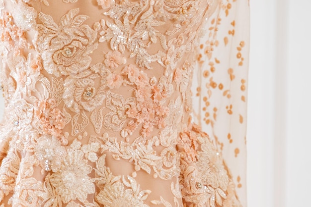 A peach colored lace dress with a gold lace bodice and a lace bodice.