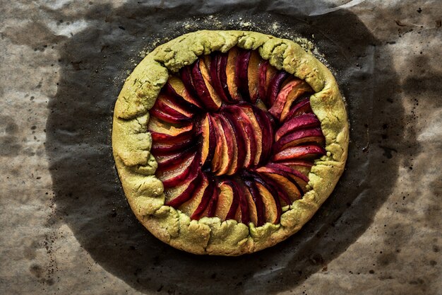 Photo peach galette on baking paper, top view