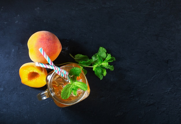 ミントと氷、夏の暑い季節に素敵な飲み物と暗い背景に桃のアイスティー