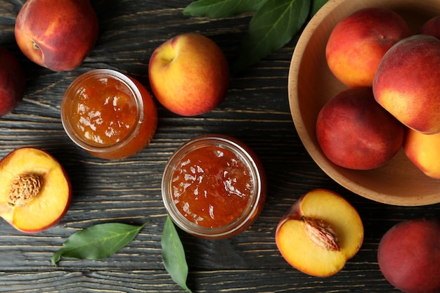 Peach jam and ingredients on rustic wooden table