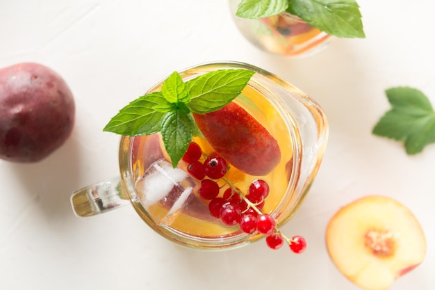 Peach lemonade in jar garnish berrycurrant mint Close up