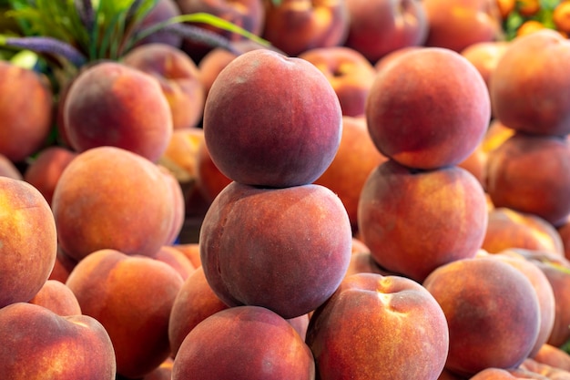 Персик на прилавке рынка Куча спелых персиков