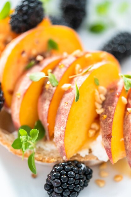 Peach ricotta toast garnished with blackberries on a white plate.