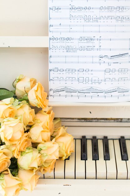 Peach roses on the piano with notes