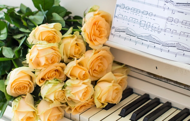 Peach roses on the piano with notes