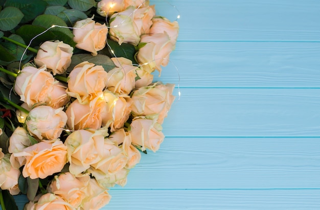 Peach roses on wooden turquoise background