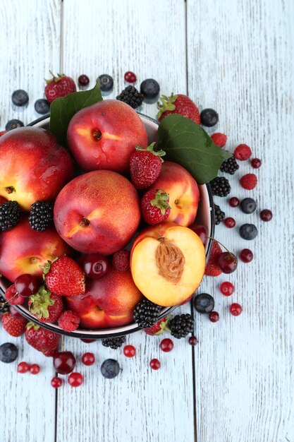 Peaches and berries in bowl on table closeup