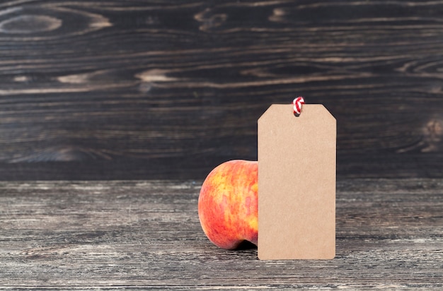 Peaches on a dark background with a label of paper for writing, the label is made from recycled waste paper