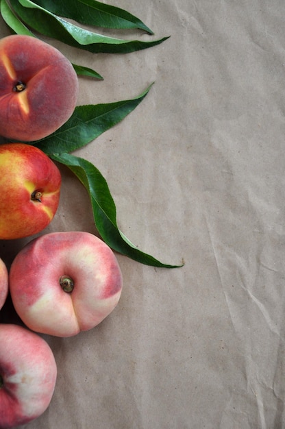peaches and nectarine with green leaves top view copy space