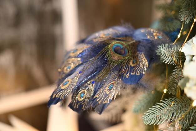 Foto una decorazione di pavone su un albero di natale con sopra una piuma blu