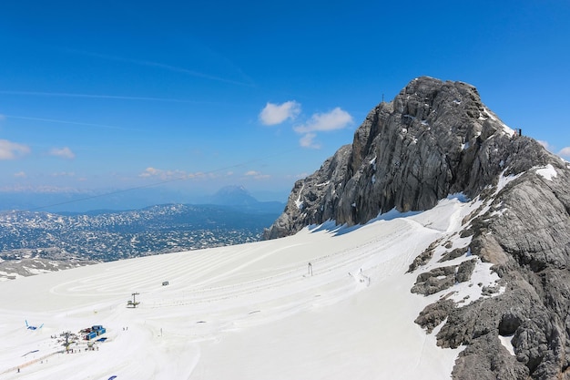 Sul picco di dachstein e visualizzare le montagne alpine. parco nazionale in austria, europa. cielo azzurro e nuvoloso in una giornata estiva