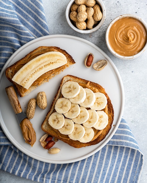 peanut butter banana sandwich in a white plate on gray surface