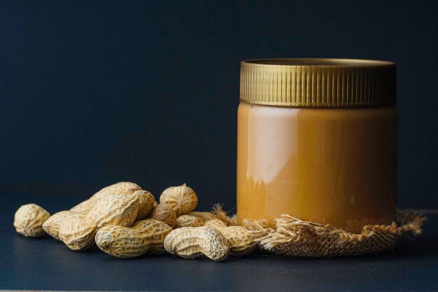 Peanut butter in the bottle and groundnut over the black background