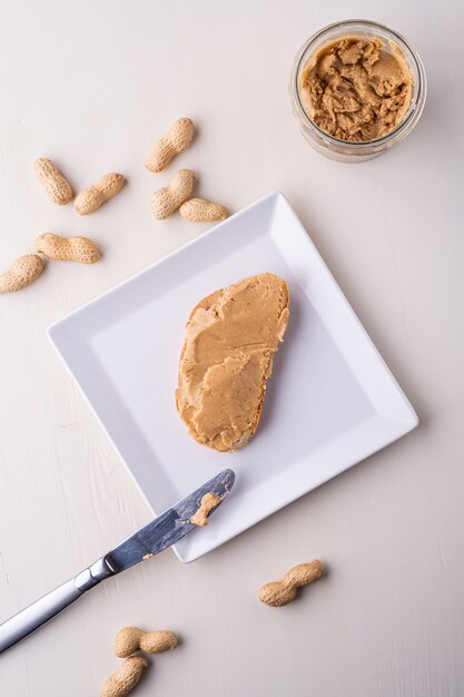 Photo peanut butter bread sandwich on white square shaped plate