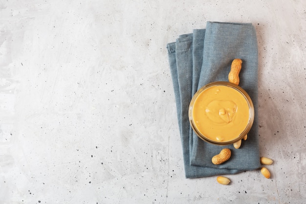 Peanut butter in a glass jar on the table, top view