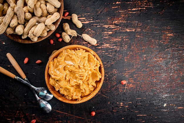 Peanut butter and inshell peanuts in wooden plates