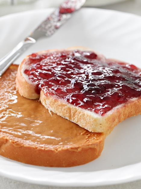 Peanut butter and jelly on pieces of bread.