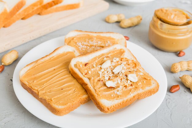 Peanut butter sandwiches or toasts on light table backgroundBreakfast Vegetarian food American cuisine top view vith copy space