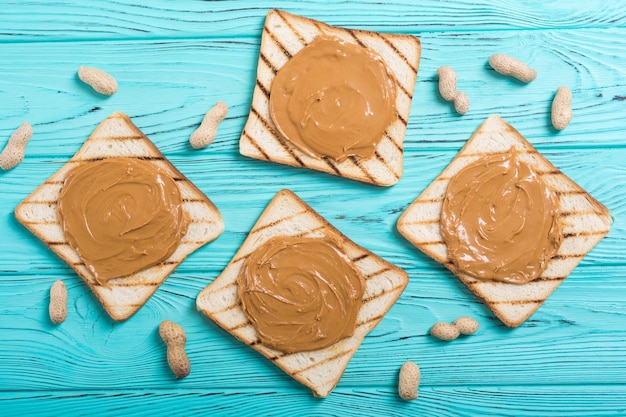 Photo peanut butter sandwiches or toasts on wooden background
