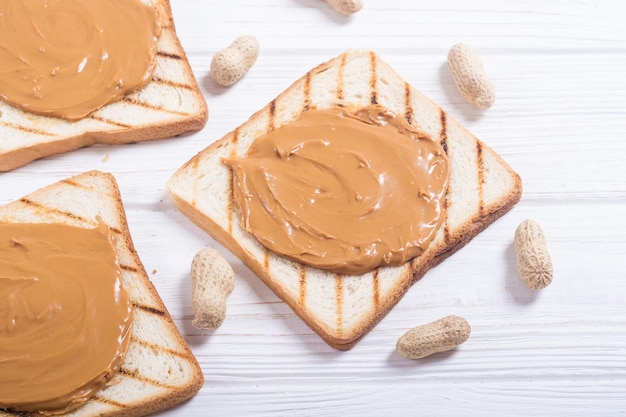 Peanut butter sandwiches or toasts on wooden background