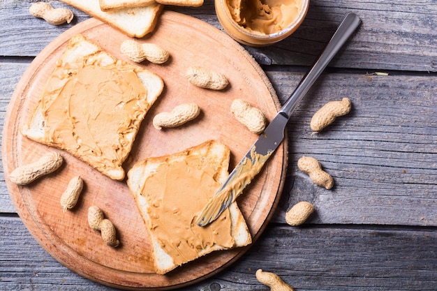 Peanut butter sandwiches or toasts on wooden background