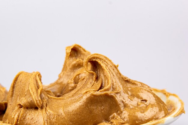 Фон текстуры арахисового масла Сливочный гладкий коричневый вихрь грецкого ореха крупным планом Вкусный темный натуральный пищевой макаронный макрос
