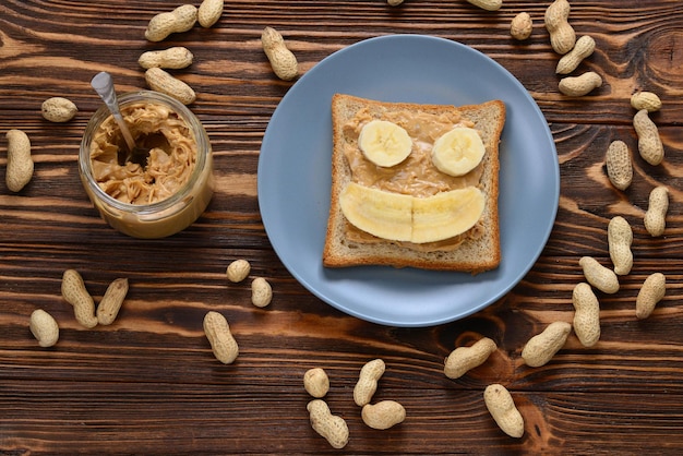 Peanut butter toast with banana slices  on wooden background
