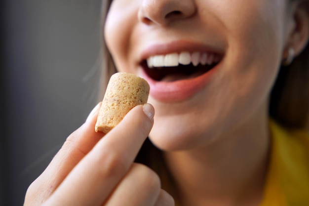 Photo peanut candy pacoca or pacoca extreme closeup of beautiful girl eating pacoca traditional brazilian peanutbased candy