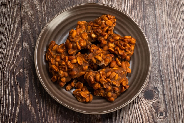 Peanut candy served in a brown silver on wooden background