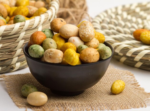 Photo peanut coated served in a bowl isolated on napkin side view of nuts on grey background