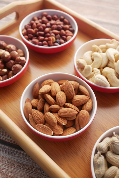 Peanut hazelnut walnut  cashew nut and almond in a container on black