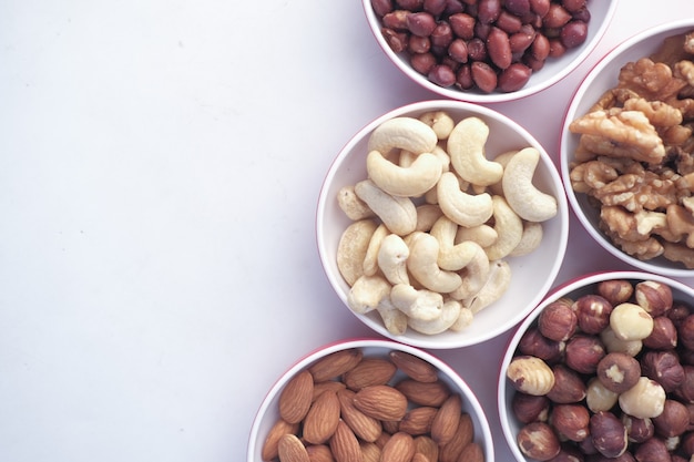 Peanut hazelnut walnut  cashew nut and almond in a container on white