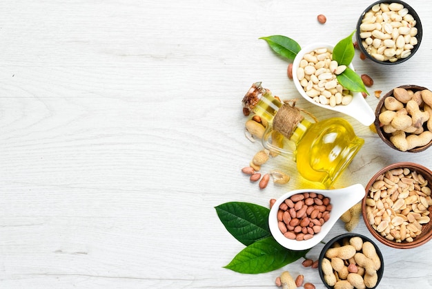 Peanut oil in jar on wooden background Top view