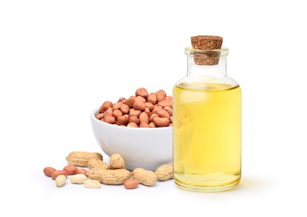 Peanut oil with peanuts isolated on white surface