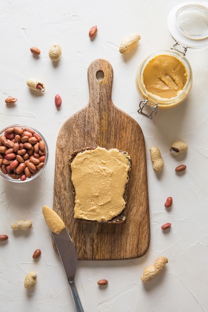 Photo peanut paste on brown wholegrain bread. healthy nutrition. view from above.