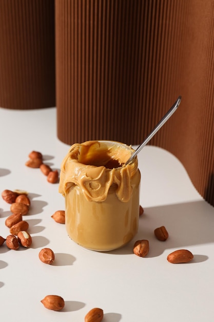 Foto peanut paste in een glazen pot op een donkere achtergrond