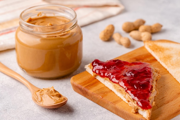 Photo peanut paste in an open jar and toast