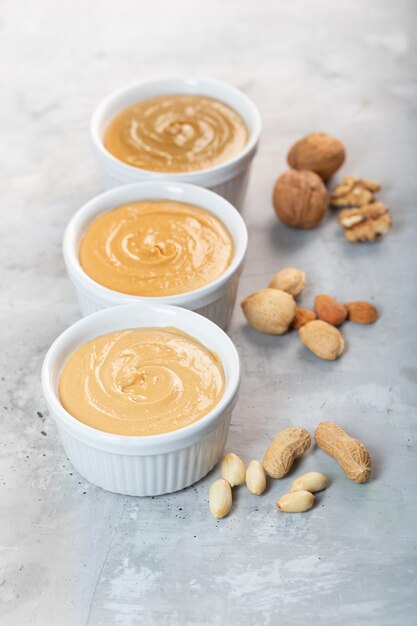 Peanut walnut and almond butter on the gray concrete background