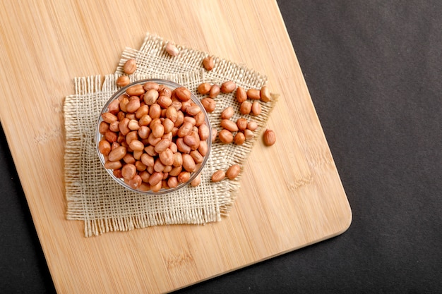 peanuts in bowl on the dark background.