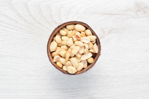 Peanuts in bowl on old table Nut background Top view